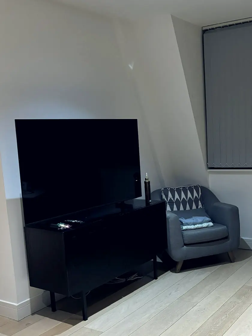 A living room with the television unit, chair and oak boards cleared and cleaned.